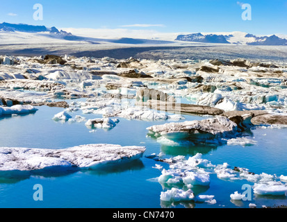 Petit iceberg en train de fondre dans la mer de l'Arctique de l'Islande avec montagnes en arrière-plan Banque D'Images