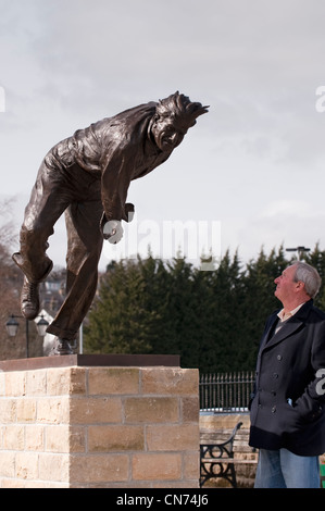 1 l'homme à la recherche jusqu'à la statue de bronze de cricketer Fred (Freddie) Trueman (fast Bower, vue de face, en action poser) - Skipton, Yorkshire du Nord, Angleterre, Royaume-Uni Banque D'Images