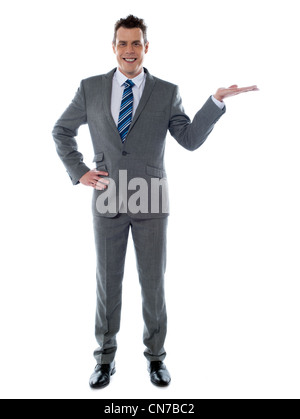 Portrait of a young businessman présentant un produit contre fond blanc - copyspace Banque D'Images