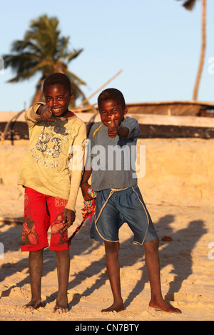 Deux garçons africains malgaches de l'ethnie Vezo donner le feu vert à un typique village de pêcheurs Vezo à distance et Banque D'Images