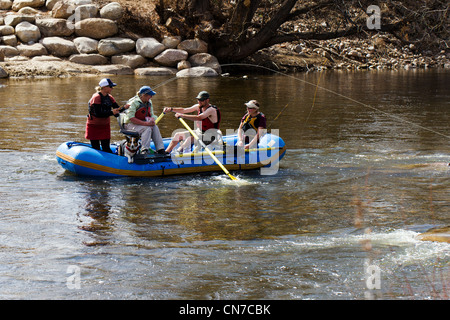 Femme pêcheur de mouche hameçons une truite à partir d'un radeau gonflable, visite guidée. L'Arkansas River, Salida, Colorado, USA Banque D'Images