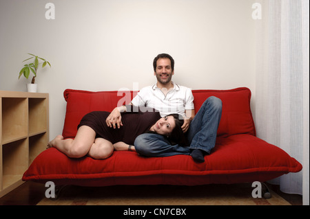 Couple assis sur un canapé dans le salon Banque D'Images