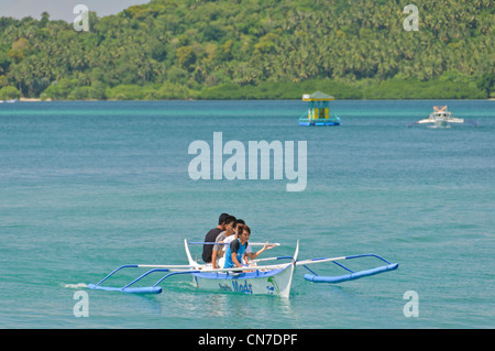 Asian Filipino quatre adolescents d'une petite circonscription banka, Philippine outrigger bateau, la baie de Puerto Galera Mindoro Philippines Asie Banque D'Images