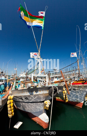 La Corée du Sud, la Province de Jeju, Corée, Seongsan drapeau (Taegukgi) et des bateaux de pêche dans le port de Seongsan Banque D'Images