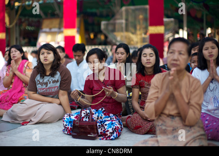 Les birmanes prier dans au site bouddhiste sacrée de Shwedagon Paya, Yangon (Rangoon), le Myanmar (Birmanie) Banque D'Images