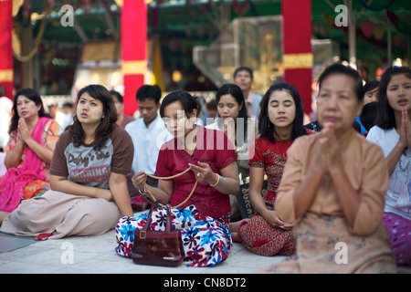 Les birmanes prier dans au site bouddhiste sacrée de Shwedagon Paya, Yangon (Rangoon), le Myanmar (Birmanie) Banque D'Images