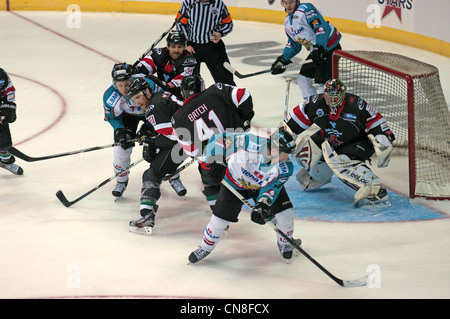 Cardiff Devils, en noir, en défendant devant leur filet de sécurité contre les géants Belfast Banque D'Images