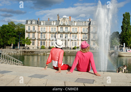 France, Meuse, Verdun, les touristes assis devant les jets d'eau contre le mess des officiers sur le quai de la République Banque D'Images