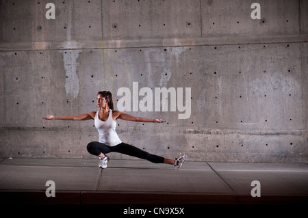 Runner stretching on sidewalk Banque D'Images