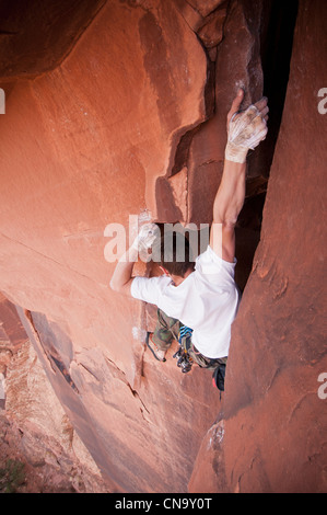 Rock climber scaling boulder crack Banque D'Images