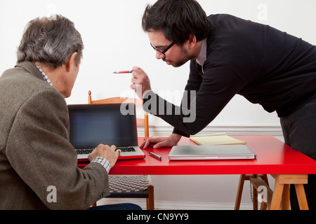 Hommes d'working together on laptop Banque D'Images