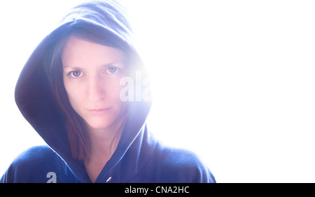 Portrait d'une jeune femme portant une capuche bleu sur fond lumineux Banque D'Images