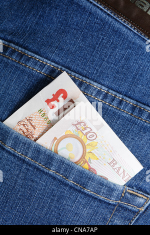 Dix livres sterling argent note en liquide dans une poche arrière, d'une paire de jeans bleu pour illustrer un concept de vie. Angleterre Royaume-uni Grande-Bretagne Banque D'Images