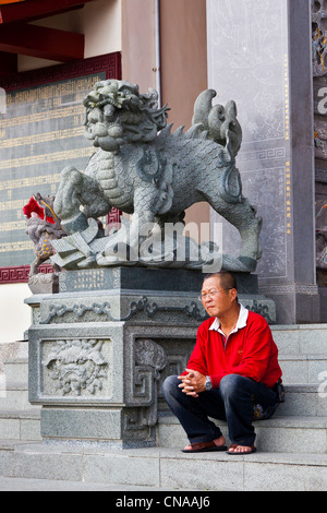 L'homme en rouge pour homme assis à côté de statue en pierre de lion sur les mesures de Wenwu Temple, Sun Moon Lake, Taiwan. JMH5850 Banque D'Images