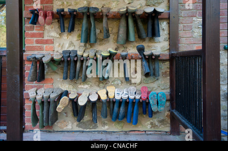 Trois lignes de bottes accrochées sur un mur Banque D'Images