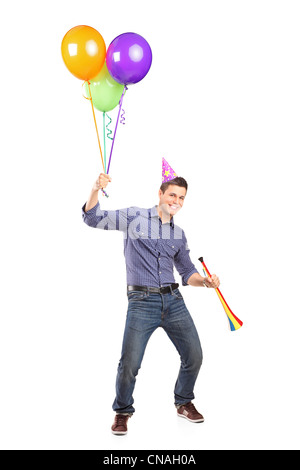 Portrait d'un homme heureux holding balloons et une corne isolé sur fond blanc Banque D'Images