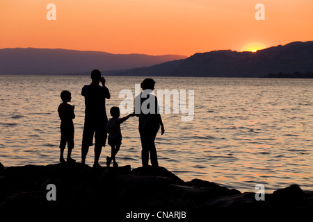 Suisse, Canton de Vaud, le lac de Genève, Veytaux, famille devant un coucher de soleil depuis le château de Chillon à Montreux du Sud Banque D'Images