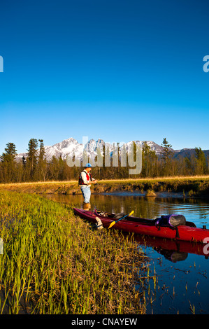 Avec un homme à la pêche en kayak à partir de la rive du marécage de lapin dans le Haystack Palmer Appartements Wildlife Refuge, Mat-Su Valley, Alaska Banque D'Images