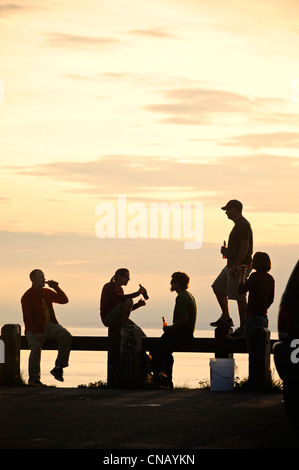 Silhouette d'un groupe de personnes au coucher du soleil au point Woronzof à Anchorage, Southcentral Alaska, l'été Banque D'Images