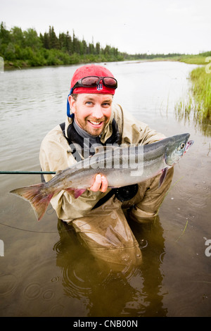 Pêcheur de mouche est titulaire d'un saumon rouge sur la Mulchatna River dans la région de la baie de Bristol, sud-ouest de l'Alaska, l'été Banque D'Images