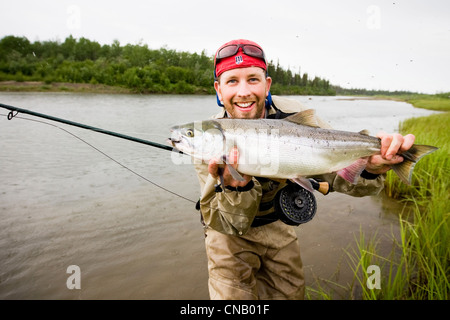 Pêcheur de mouche est titulaire d'un saumon rouge sur la Mulchatna River dans la région de la baie de Bristol, sud-ouest de l'Alaska, l'été Banque D'Images