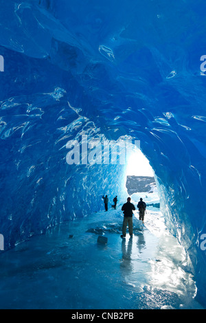 Groupe de personnes à l'intérieur d'une grotte de glace d'un iceberg dans le lac gelé de Mendenhall, Juneau, Alaska du Sud-Est, l'hiver Banque D'Images