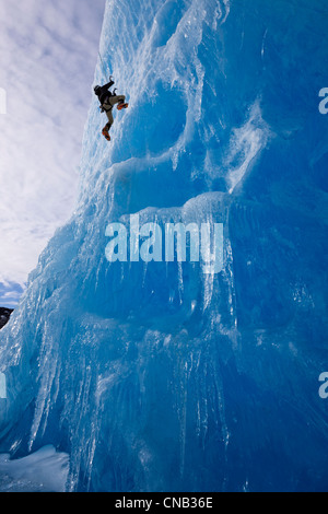 Un grimpeur sur glace monte sur le visage d'un gros iceberg frozen dans Mendenhall Lake, Juneau, Alaska du Sud-Est, l'hiver Banque D'Images