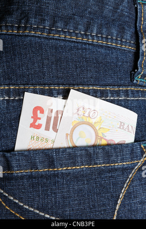 Une note de dix livres dans la poche arrière d'une paire de jeans en denim bleu femme Banque D'Images