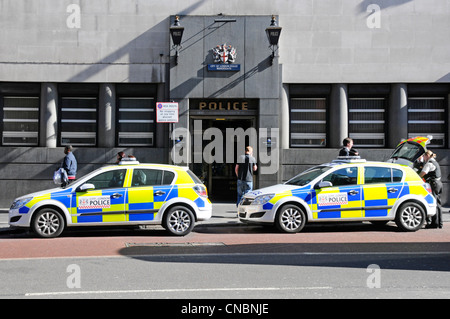 Les agents de police en uniforme à côté de voitures de police stationnées à l'extérieur Ville de Londres d'entrée de station de police Bishopsgate & blue lampes et les passants non connectés Banque D'Images