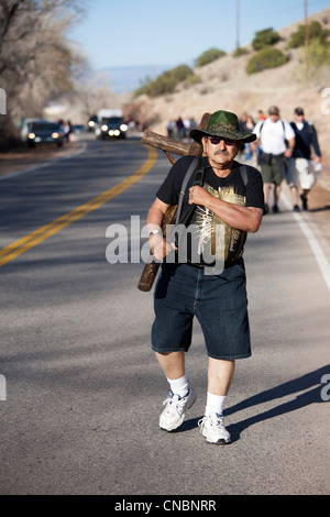 Pilgrim portant une croix sur son chemin à la Sanctuaire Chimayo, Nouveau Mexique, au cours de la semaine de Pâques. Banque D'Images