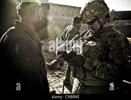 SPC. Derek Jordan, medic, Able Company 3-66, 1er Bataillon, 2e Régiment d'infanterie, 172e Brigade d'infanterie, scanne le doigt d'un afghan lors d'une mission d'assaut aérien dans la province de Ghazni, Afghanistan, mars 21. Les soldats, aux côtés de l'Armée nationale afghane, ont cherché dans deux villages des trésors d'activités insurgées et d'armes. Banque D'Images