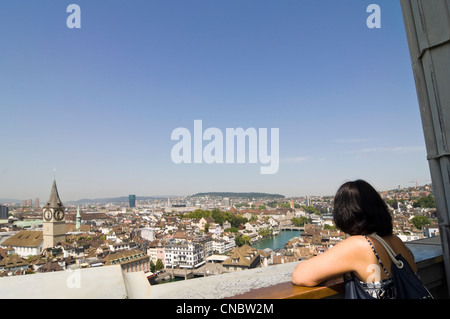 Grand angle horizontal d'une femme en profitant de la vue du centre historique de Zürich sur une journée ensoleillée de l'Grossmunster. Banque D'Images