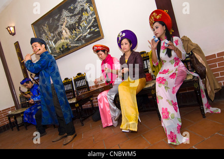 Vue horizontale d'une troupe de musiciens traditionnels vietnamiens jouer et chanter des chansons du folklore traditionnel en costume. Banque D'Images