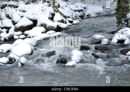 Un barrage sur une rivière en hiver, avec la neige sur les pierres, rivière : La Varenne (Orne, Normandie, France). Banque D'Images
