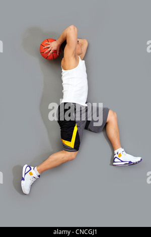 Guy jumping à marquer un but jouer au basket-ball Banque D'Images
