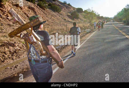 Pilgrim portant une croix sur son chemin à la Sanctuaire Chimayo, Nouveau Mexique, au cours de la semaine de Pâques. Banque D'Images