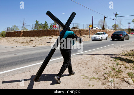 Pilgrim portant une croix sur son chemin à la Sanctuaire Chimayo, Nouveau Mexique, au cours de la semaine de Pâques. Banque D'Images