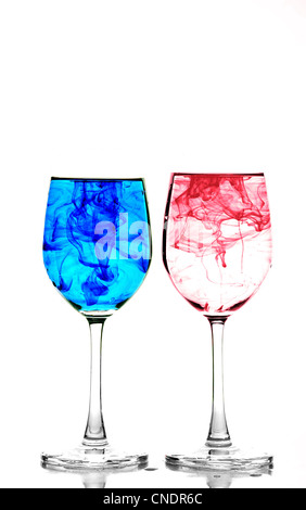 Deux verres à vin remplie d'eau et de répandre l'encre bleue et rouge Banque D'Images