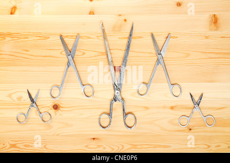 Différents types de ciseaux allongé sur une surface en bois sous la forme XXXXX Banque D'Images