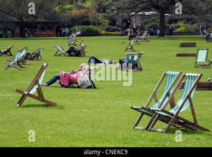 Les gens se détendre sur des chaises longues à St James Park London Banque D'Images