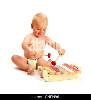 Un mignon bébé garçon jouant un xylophone instrument de musique isolé sur fond blanc Banque D'Images