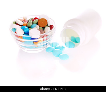 Flacon blanc bleu transparent avec des comprimés et soucoupe avec de nombreux comprimés de couleur Banque D'Images