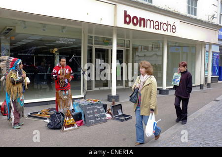 Les amuseurs publics d'Amérique du Sud et la vente de bijoux de la rue à l'extérieur d'un magasin fermé vers le bas en Falmouth, Cornwall Banque D'Images