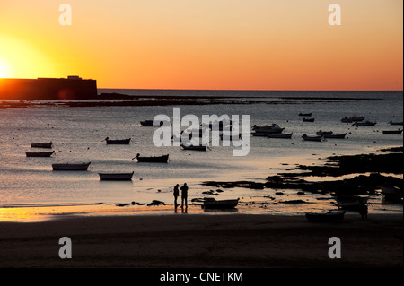 Montres Couple Coucher du soleil sur la plage de La Caleta, Cadix, Andalousie, Espagne Banque D'Images