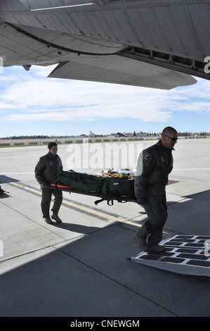 Wyoming Air National Guardmen le 2e Lt Michael Ryan, de Greeley, au Colorado, et le 1er Lt Jodi Smith, de Bridgeport, au ONÉ, chargent du matériel médical à bord d'un avion cargo C-130, à la base de la Garde nationale de l'air du Wyoming, à Cheyenne, au Wyo., le 13 avril 2012, pour une mission d'entraînement. Les deux lieutenants sont des infirmières de vol du 187e Escadron d'évacuation aéromédicale du Wyoming. L'unité est spécialisée dans la prestation de services d'ambulance aérienne à bord des avions de la Force aérienne, transportant les malades et les blessés des zones de combat vers des endroits plus sûrs. Banque D'Images