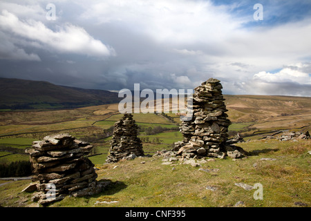 Tôt le matin, la lumière, les paysages et trois en pierre calcaire, Cairns sur colline à Abbotside, près de Hawes, Wensleydale, North Yorkshire, UK Banque D'Images