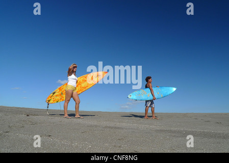 Les surfeurs avec planche de surf à la vague de l'océan pacifique droit copie espace plage pittoresque paysage M. Banque D'Images