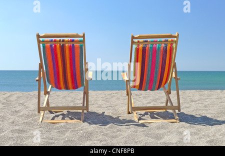 Deux chaises sur la plage de sable de l'été ensoleillé jour ciel bleu clair rivages océaniques voir copy space Banque D'Images