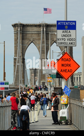 L'homme afro-américain de vendre des bouteilles d'eau, pont de Brooklyn pour piétons, vers la tour de suspension drapeau américain, New York Banque D'Images