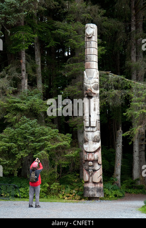 Femme prend une photo du totem Tlingit au parc historique national de Sitka, Sitka, Alaska, USA Banque D'Images